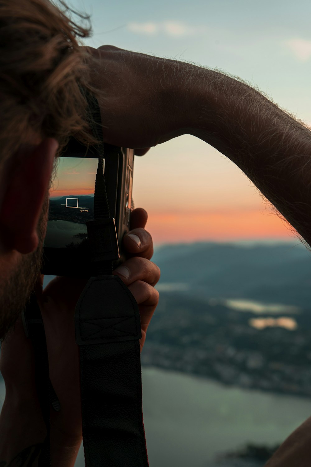 a person taking a picture of a sunset