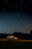 A car interior glowing softly with star roof lights under a clear night sky.