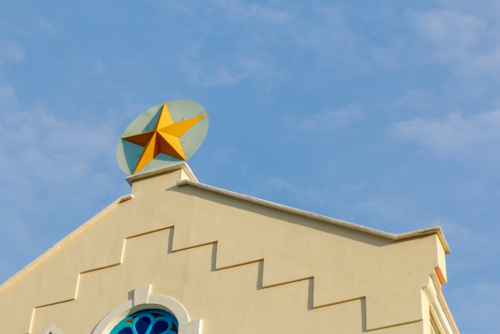 a yellow and blue building with a butterfly on the roof