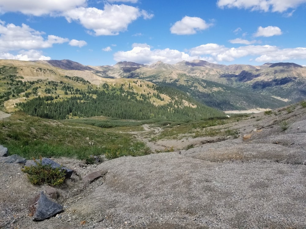 a dirt road leading up to a mountain range