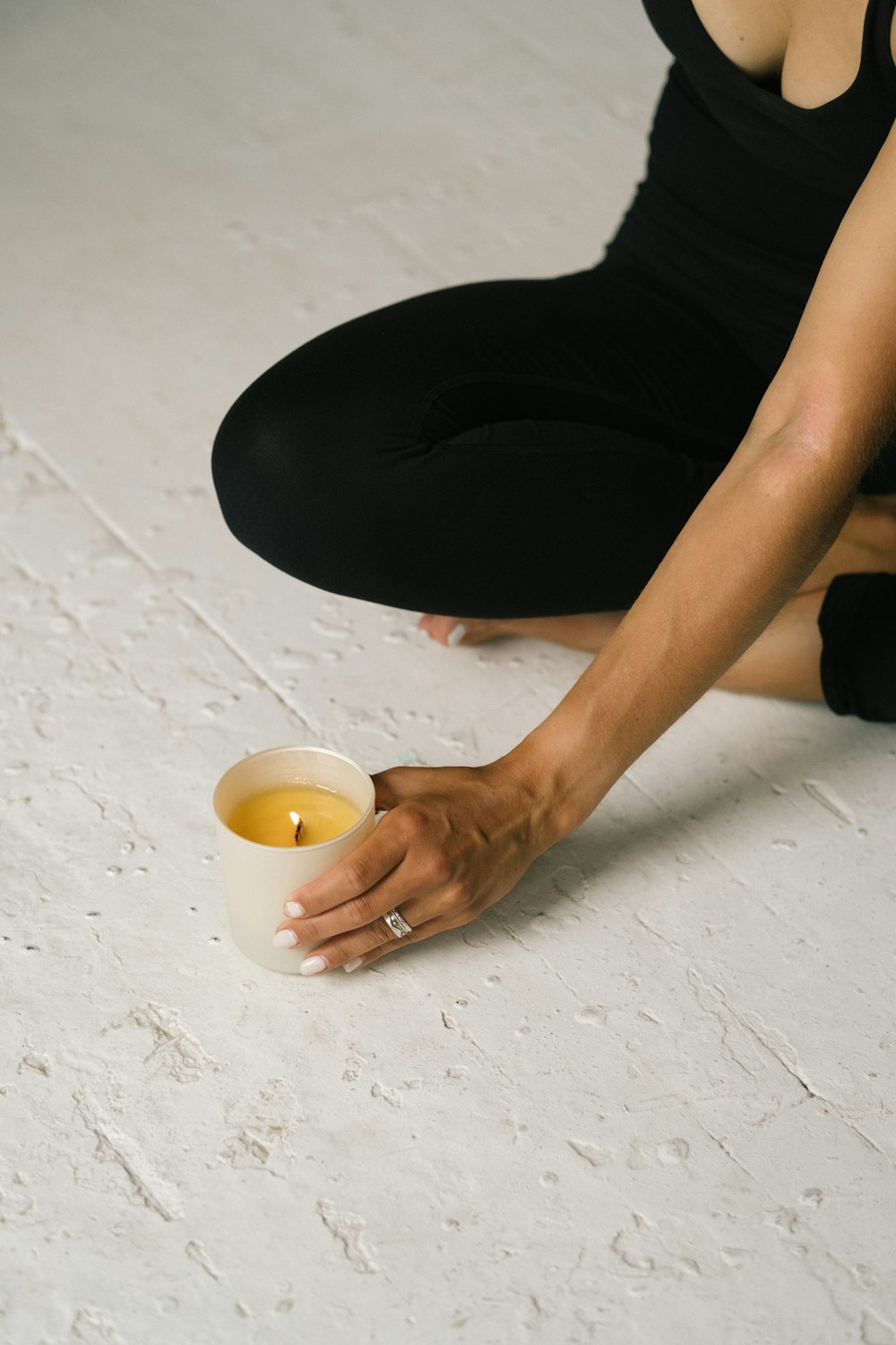 a woman sitting on the ground with a cup of tea