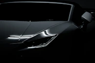 Side profile of a sporty luxury coupe with reflections emphasizing its aerodynamic design.
