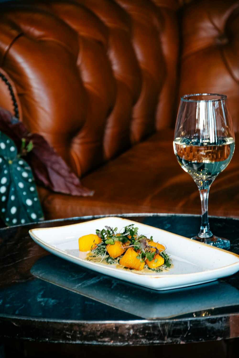 a plate of food and a glass of wine on a table