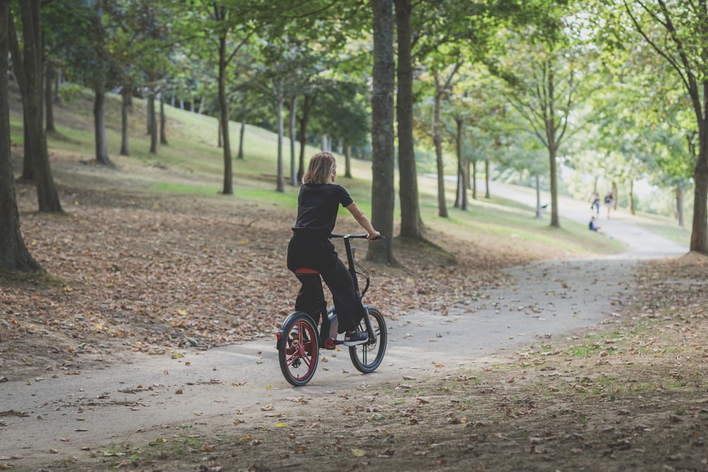 a man riding a bike on a path in a park