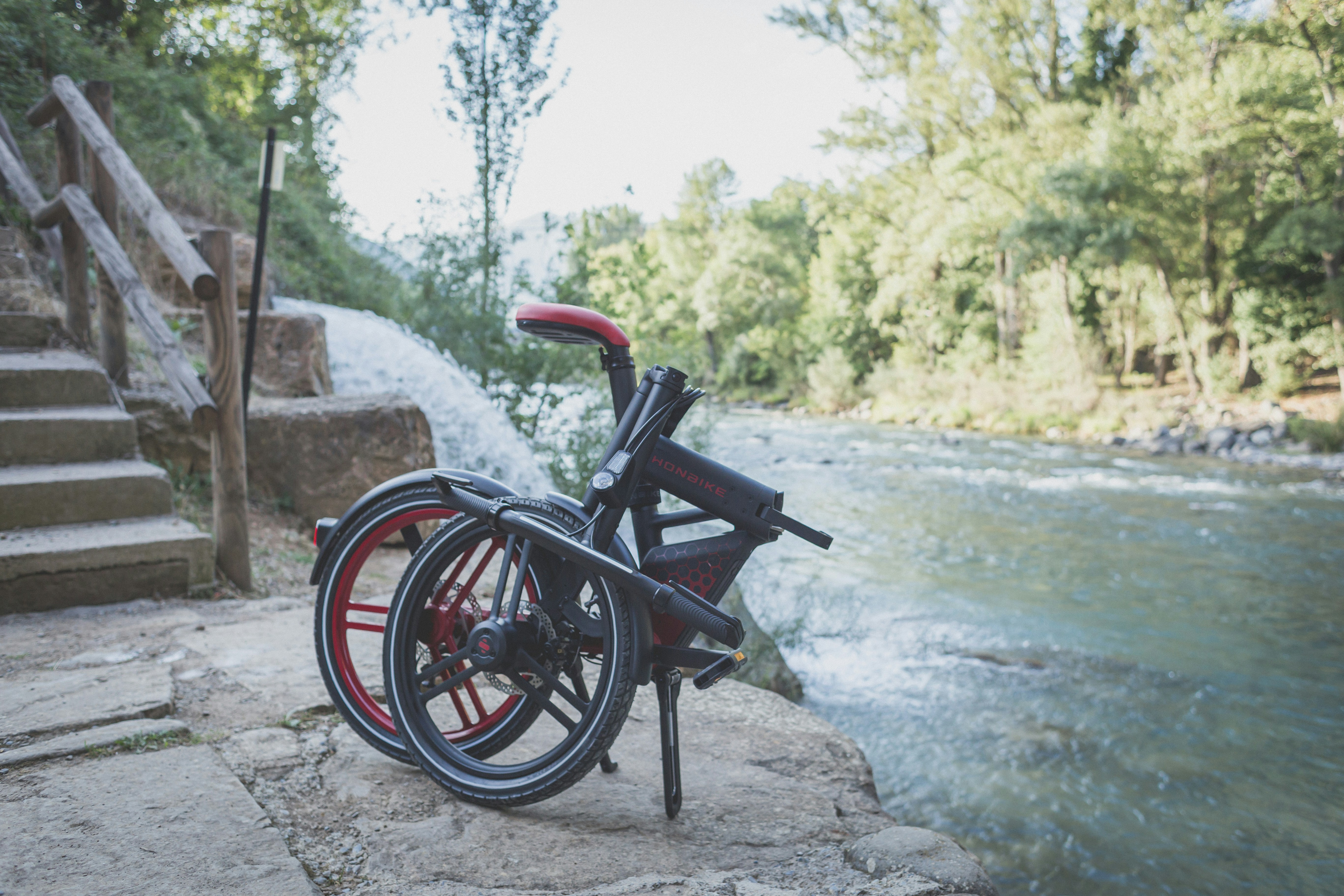 a bicycle parked on a stone path by a river