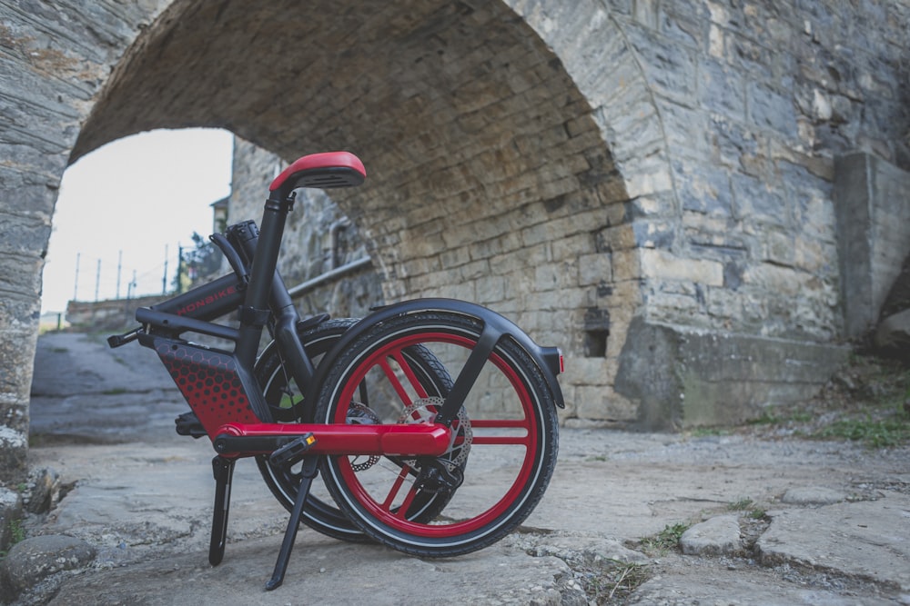 a red bicycle parked in front of a stone building