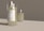 A close-up view of an elegant scented candle placed in a transparent glass holder, with the words 'Aroma Candle. A natural scent.' displayed on the label. Another similar candle is visible in the blurred background, enhancing the atmosphere.