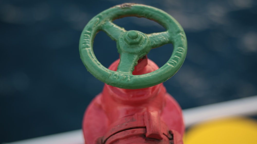 a red fire hydrant with a green tube attached