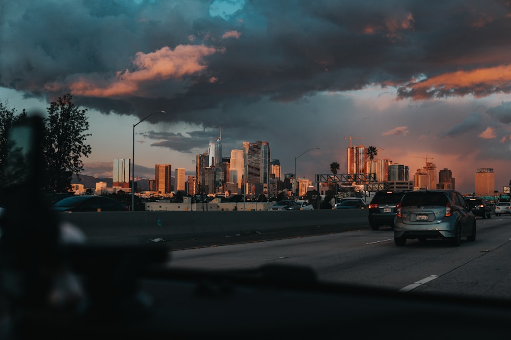 cars on a road with a city in the background