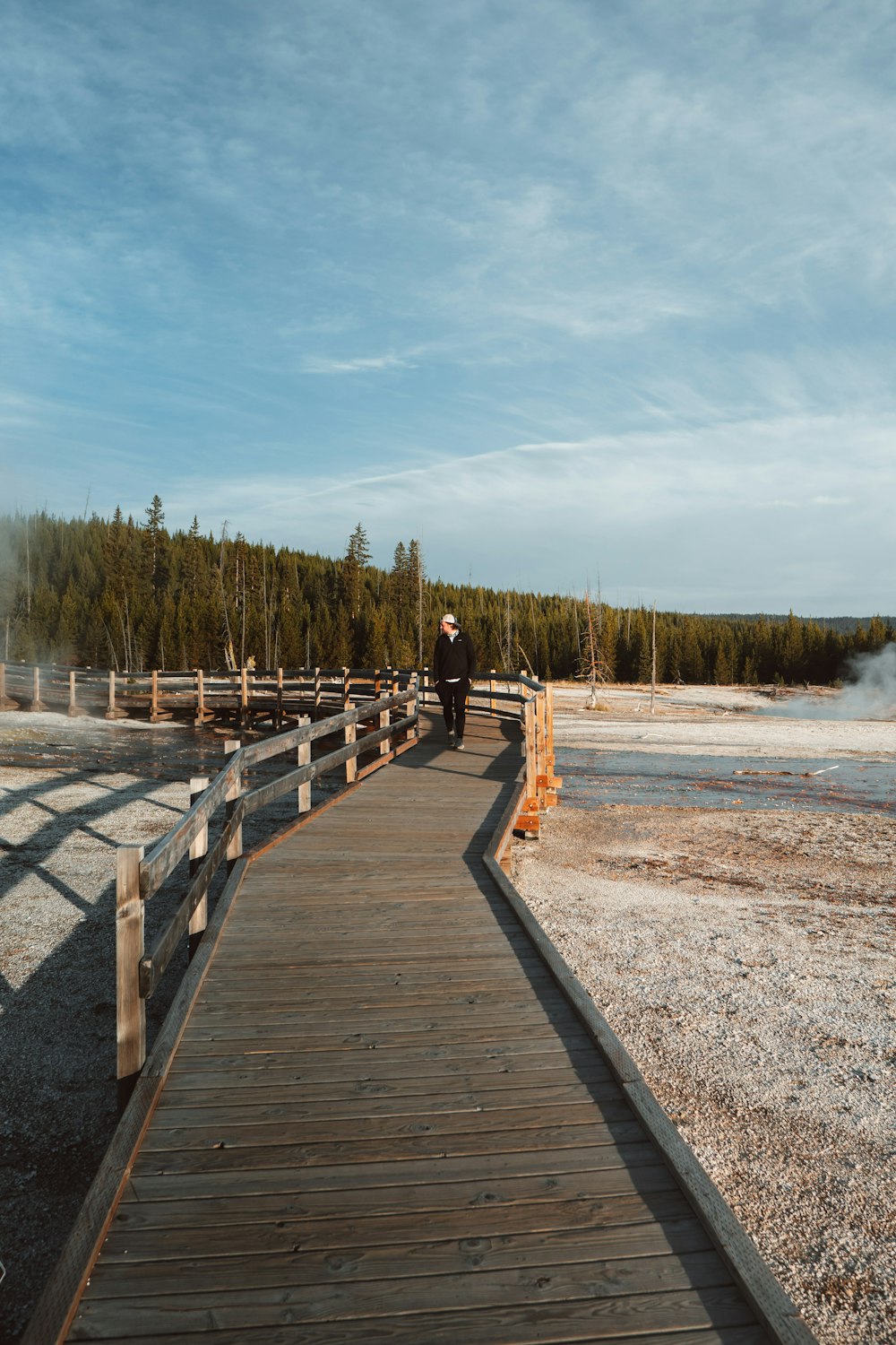 a person walking on a wooden bridge