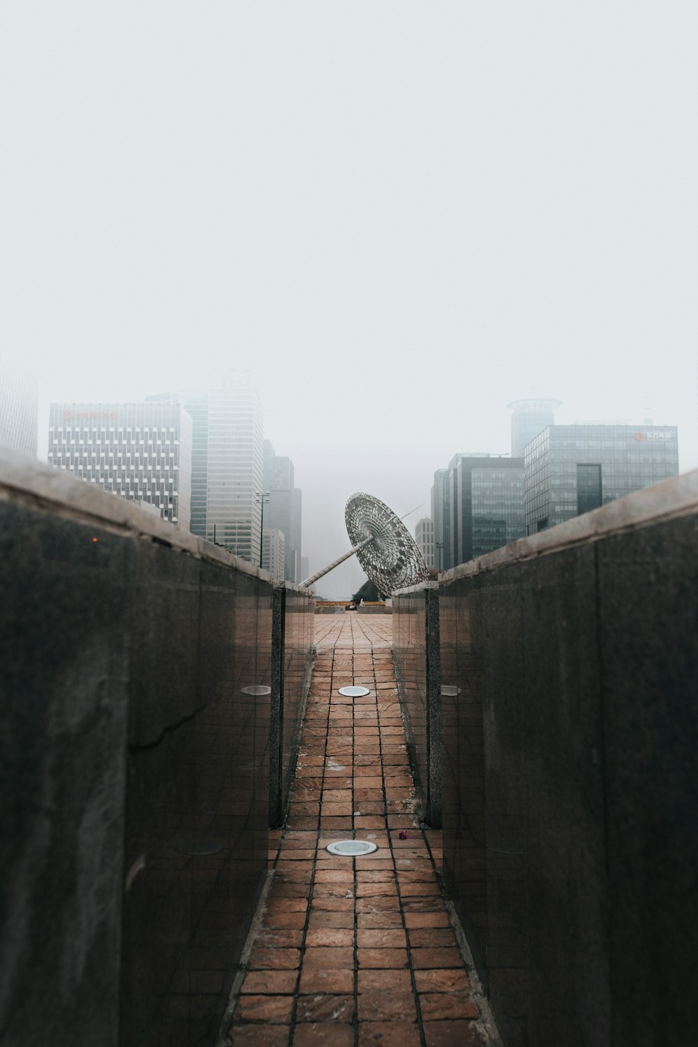 a brick walkway with a ferris wheel in the background