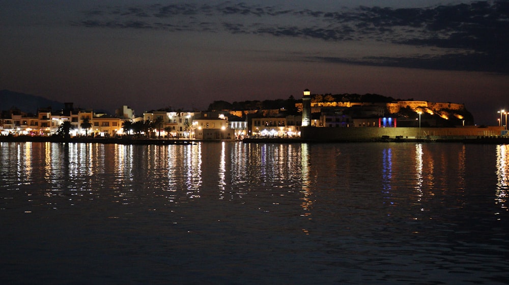 Eine Stadt neben einem Gewässer in der Nacht