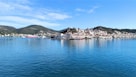 a body of water with buildings and hills in the background