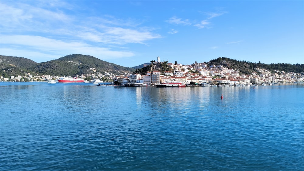 a body of water with buildings and hills in the background