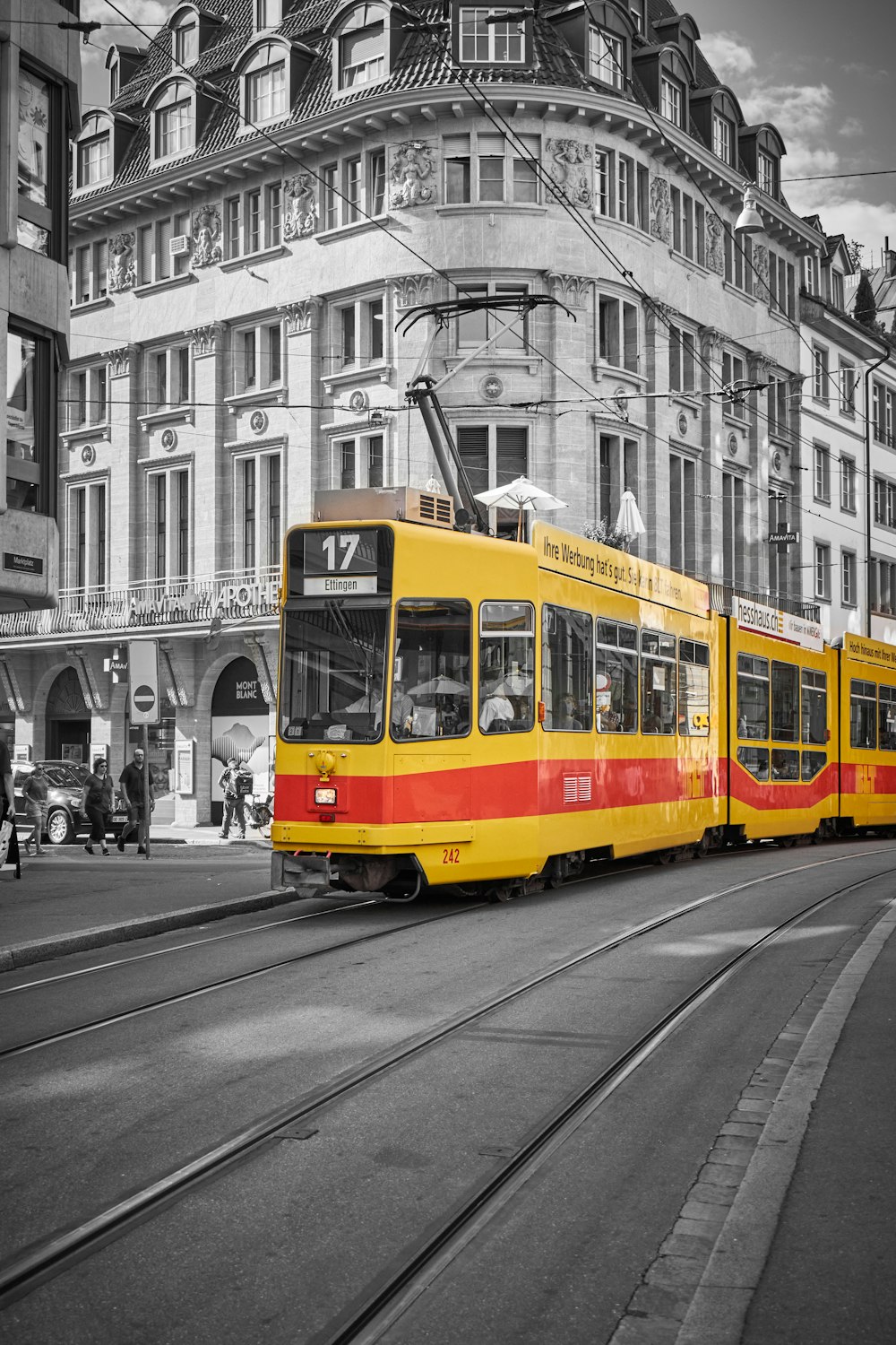 a yellow and red trolley on a street