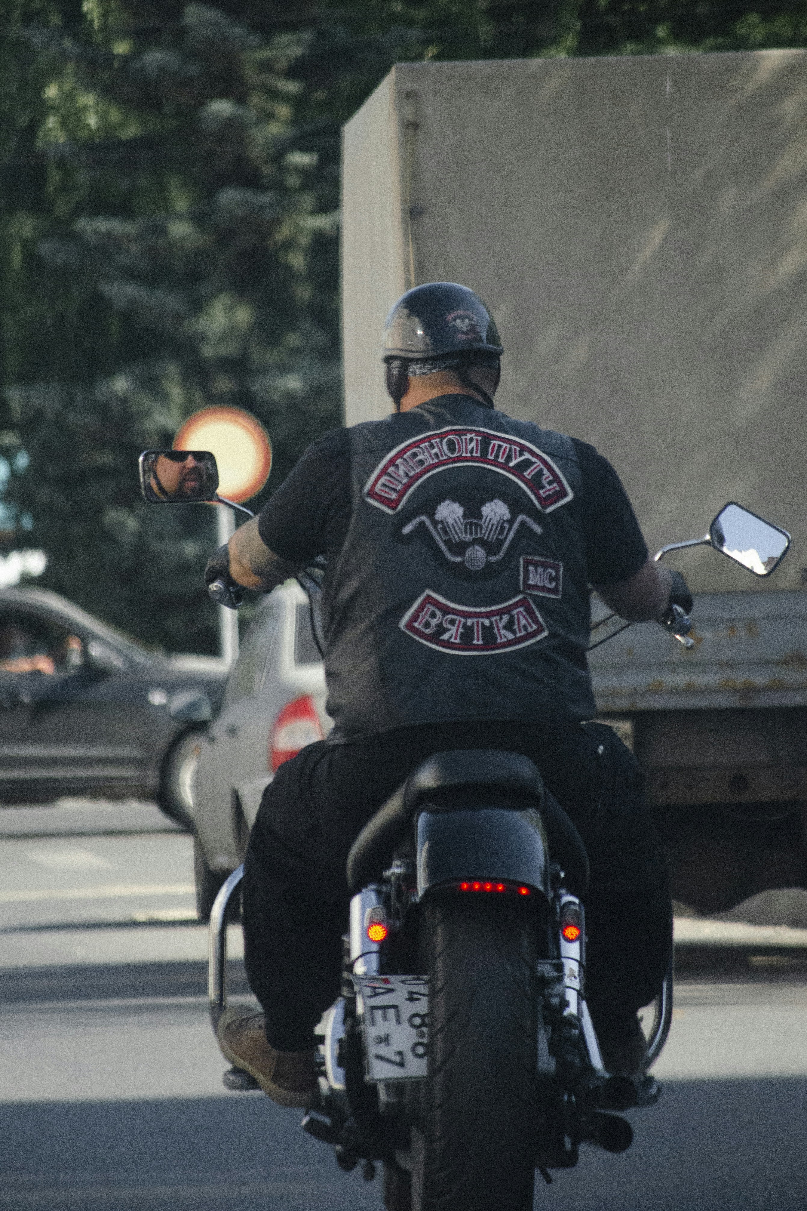 Leather motorcycle vest with patches on dark background, close-up atmospheric shot with low-key lighting