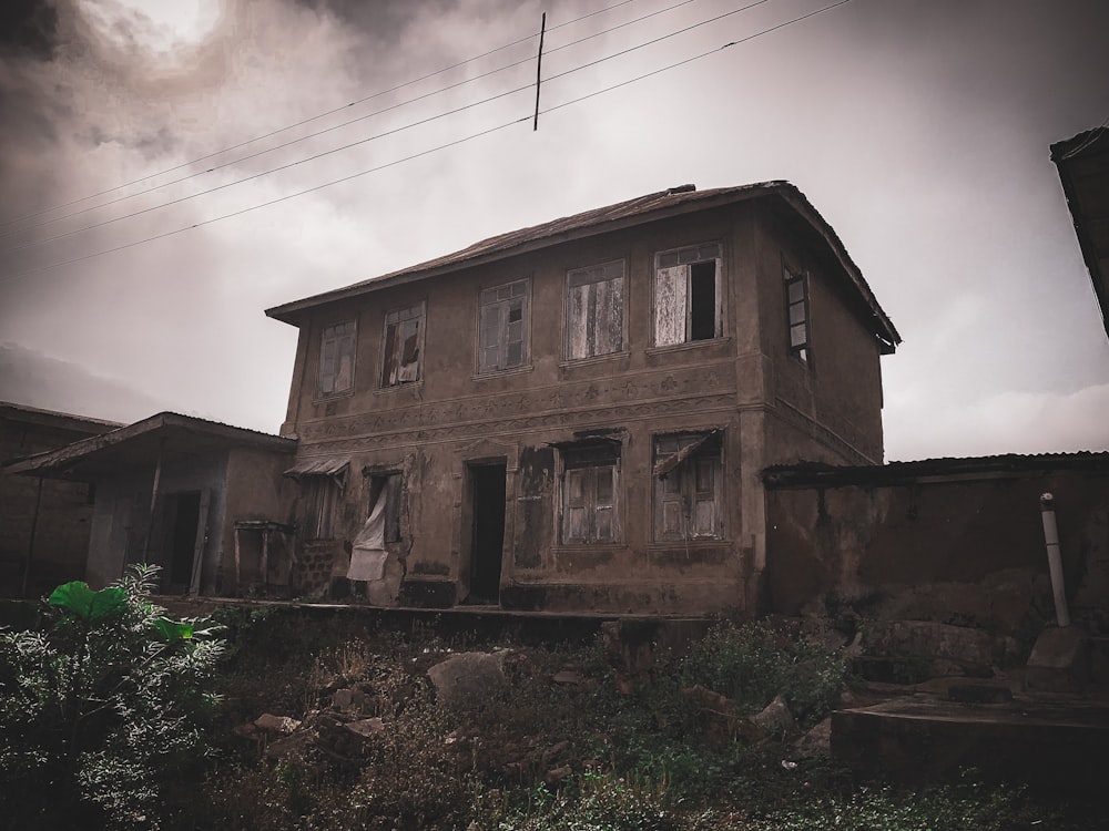 a dilapidated house with a cloudy sky