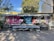 A vibrant outdoor seating area with colorful plants and artistic murals, perfect for dining.