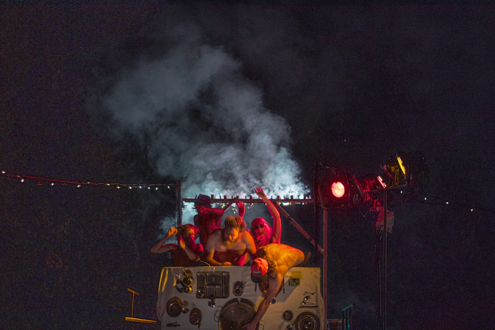 a group of people on a boat with smoke coming out of it