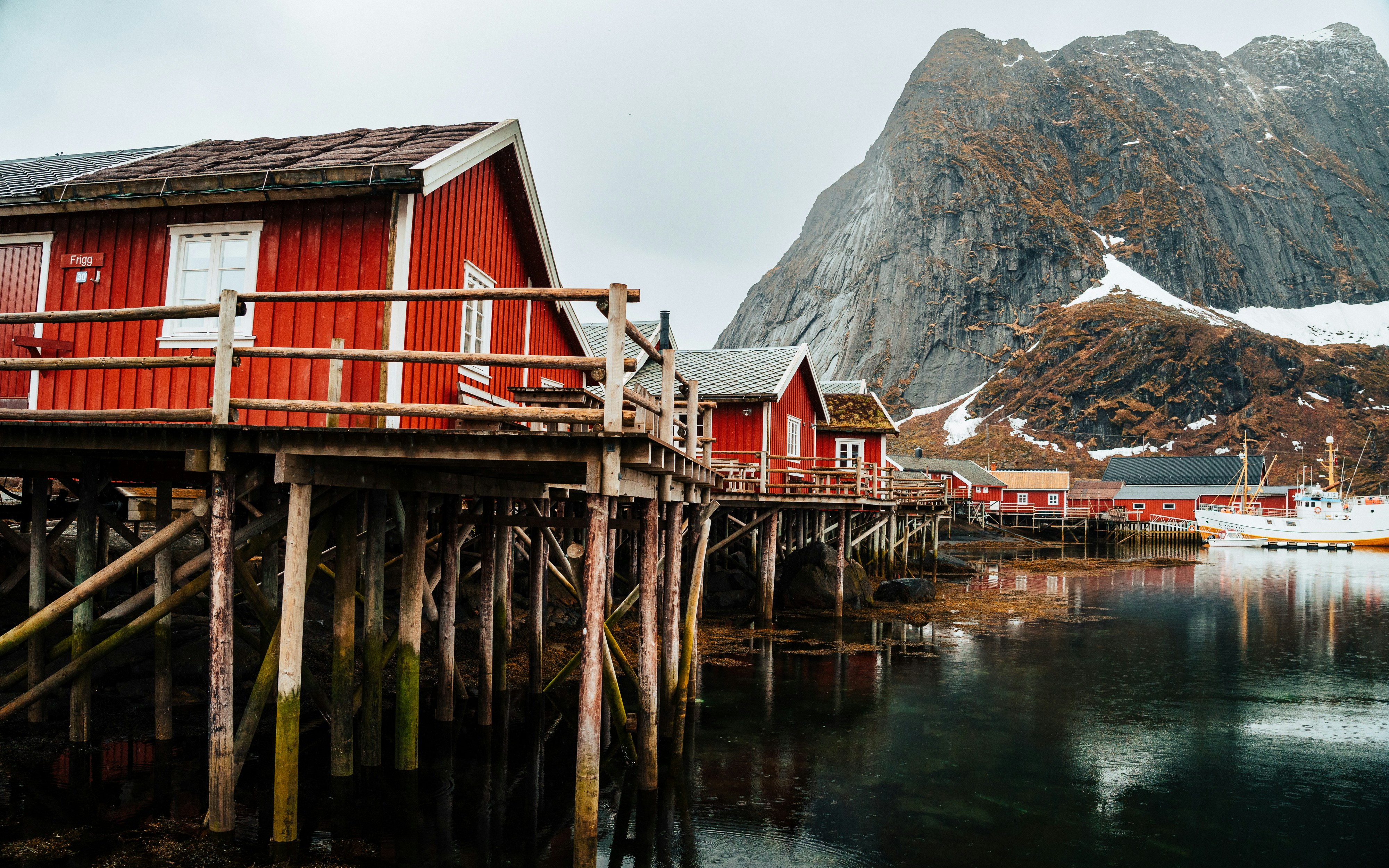 red rorbu cabins with mountain backdrop in lofoten, norway