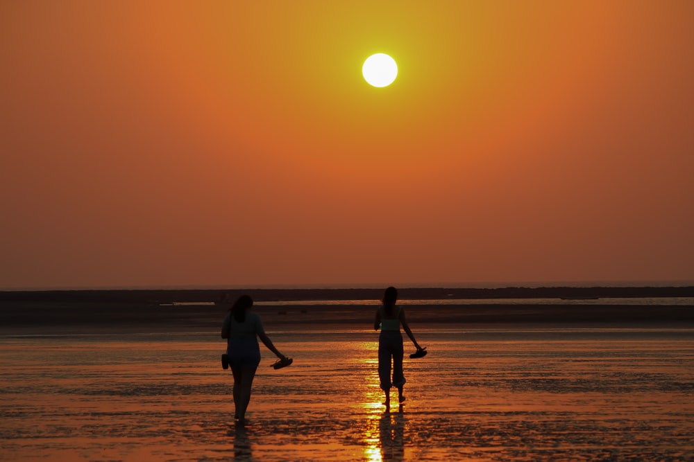 Un grupo de personas caminando por una playa al atardecer