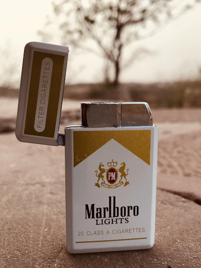 Close-up of a sleek cigarette pack with a modern minimalist design on a wooden table.