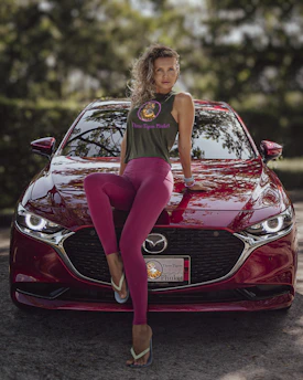 Close-up of a plus-size model wearing a bold V8 muscle car graphic tee in vibrant red.