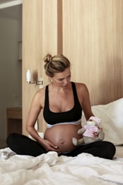 a woman in a black tank top holding a stuffed animal