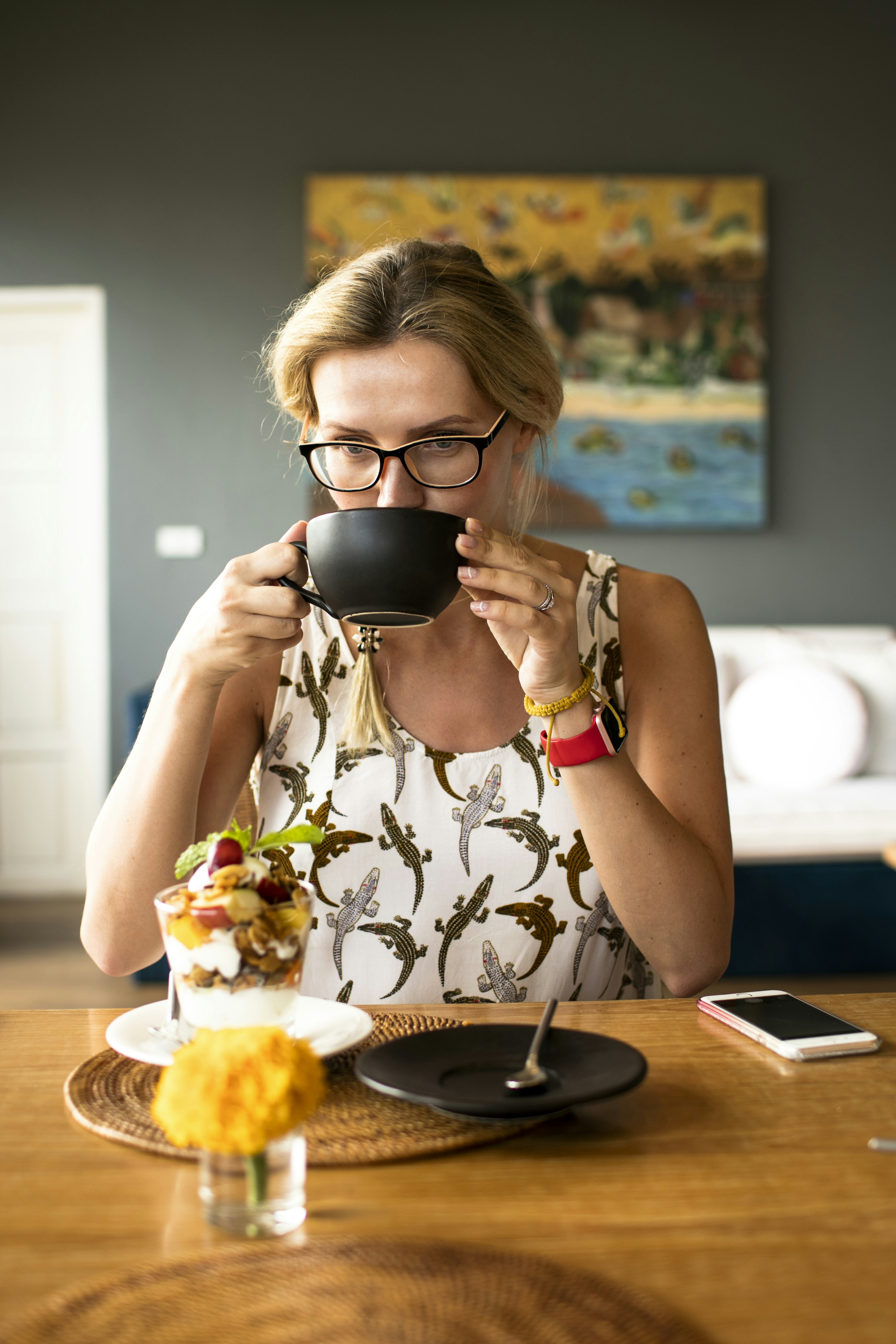 A woman in her fifties enjoying a quiet morning drink at her kitchen table