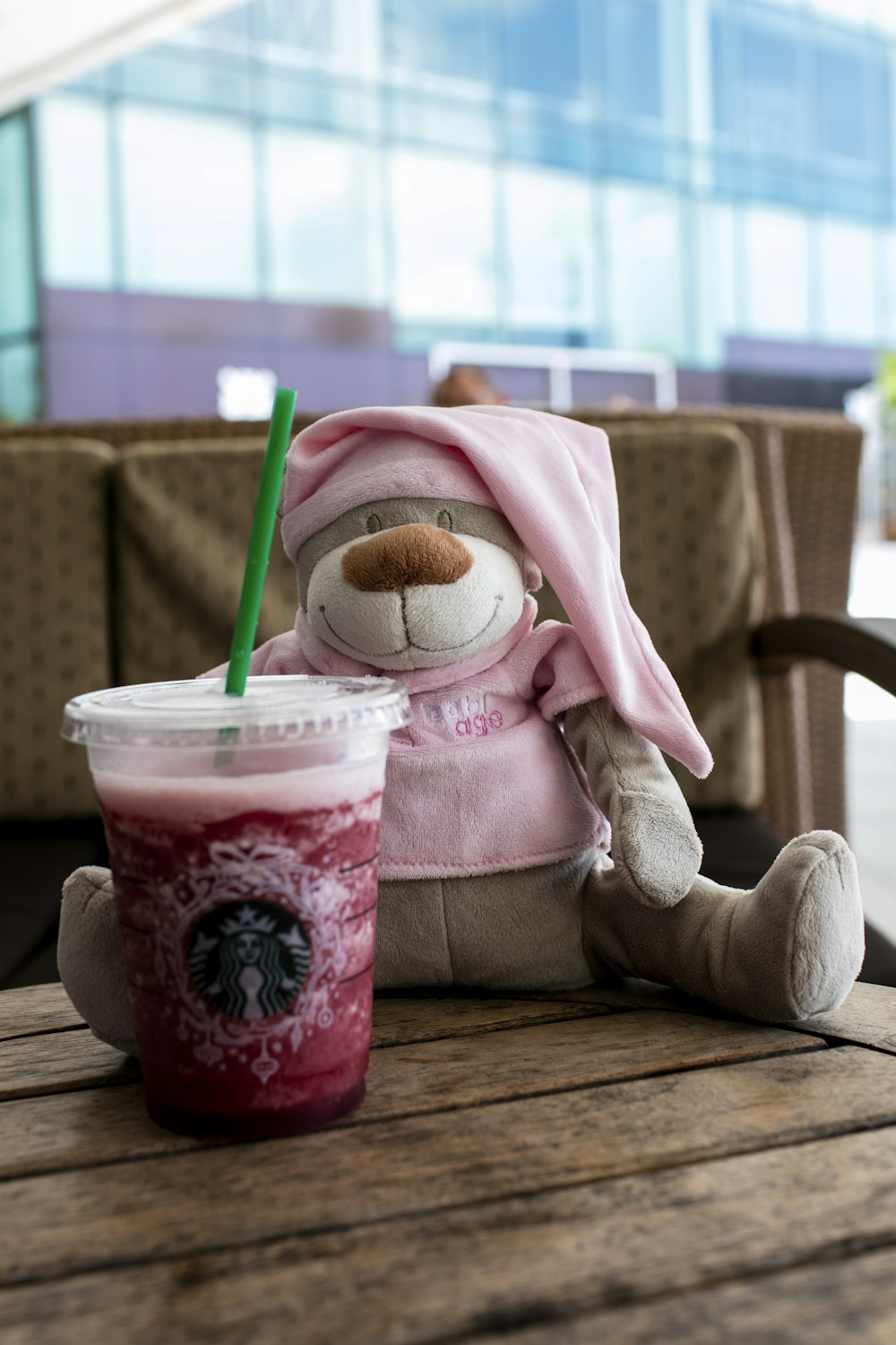 a stuffed animal next to a drink