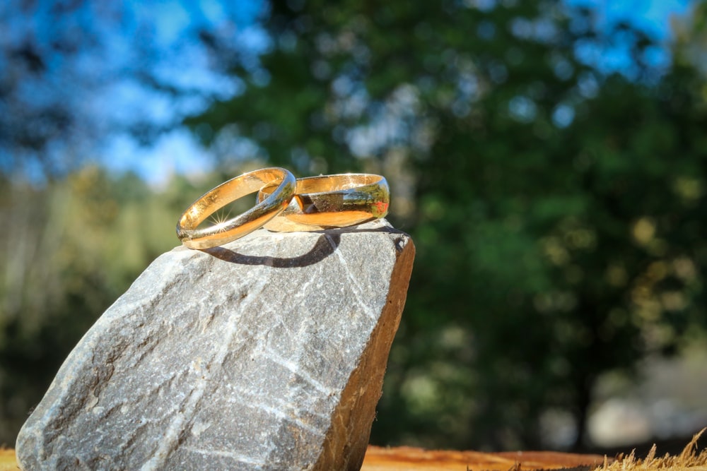 a pair of gold rings on a rock