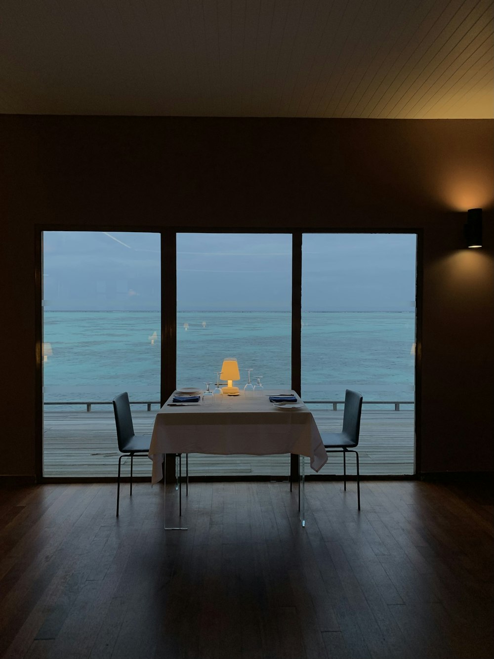 a table with chairs and a view of the ocean