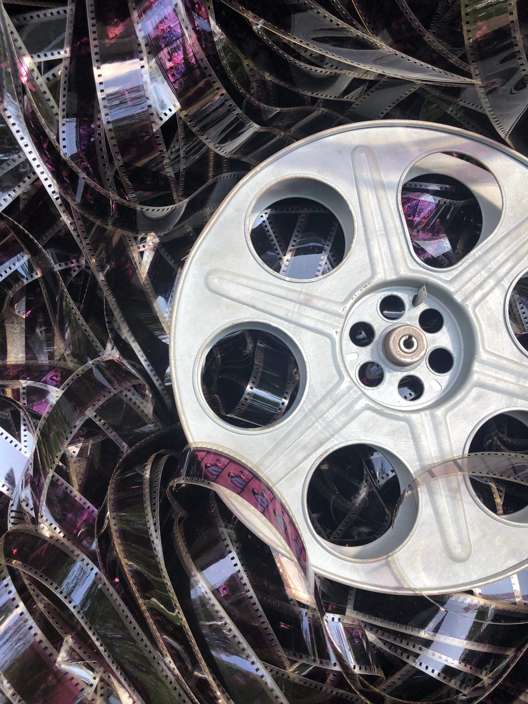 A metal film reel loaded with 35 mm film, seen close up