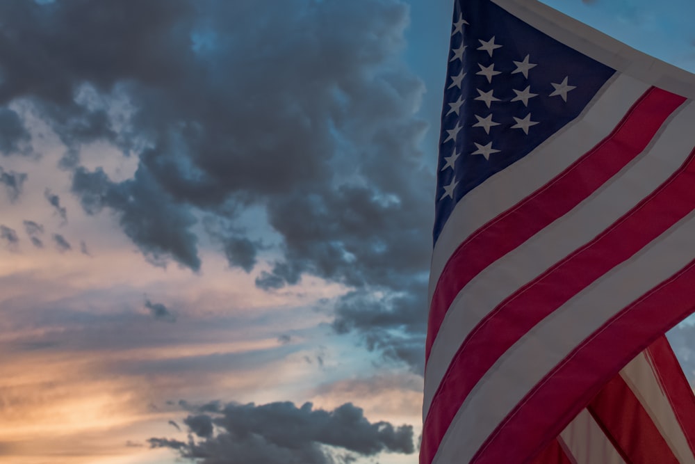 a flag with a blue sky and clouds in the background