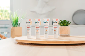 A cheerful family using skincare products with soft, natural packaging in a bright bathroom setting.