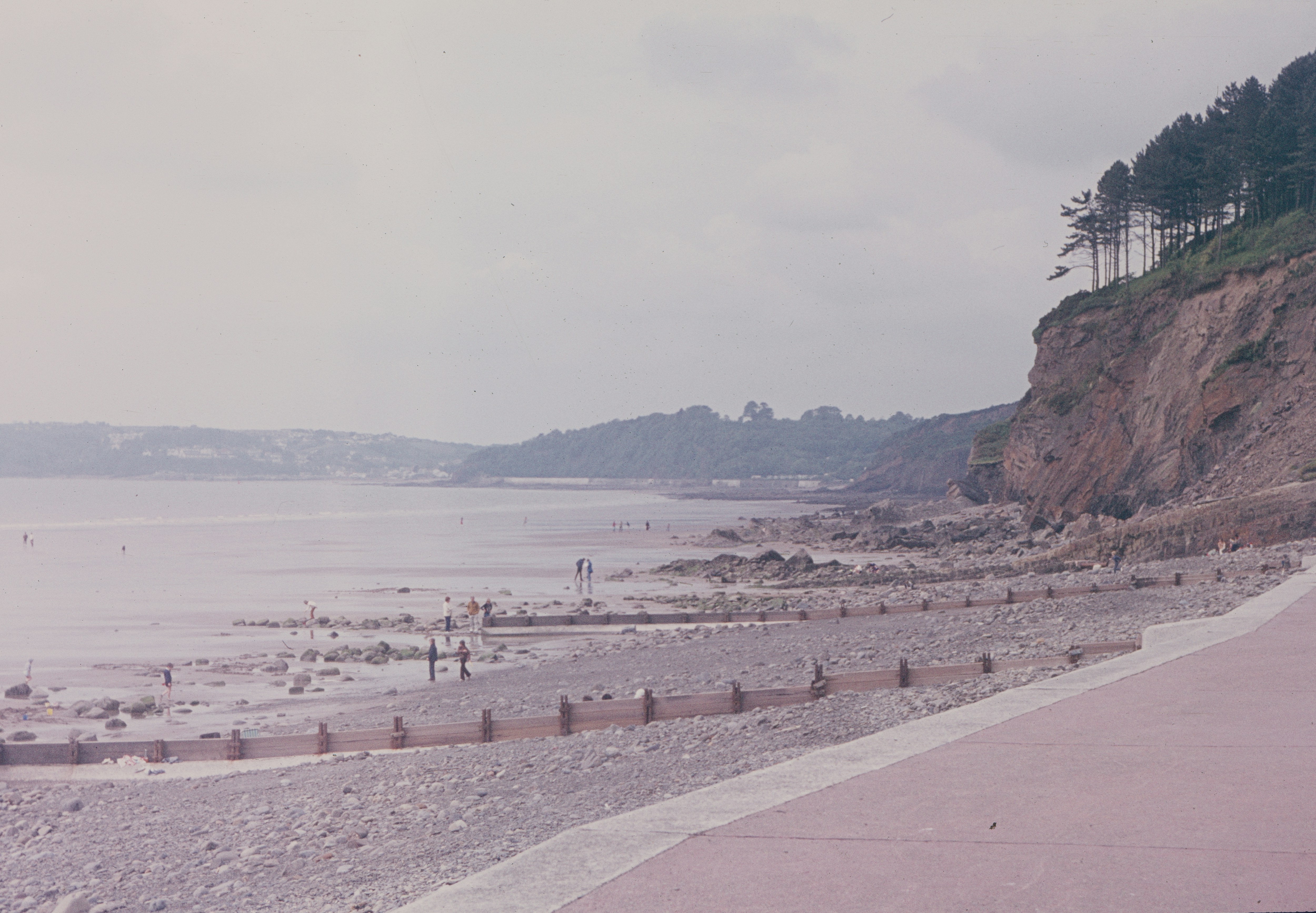 a beach with people walking on it