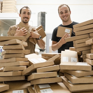 a couple of men standing next to a pile of boxes