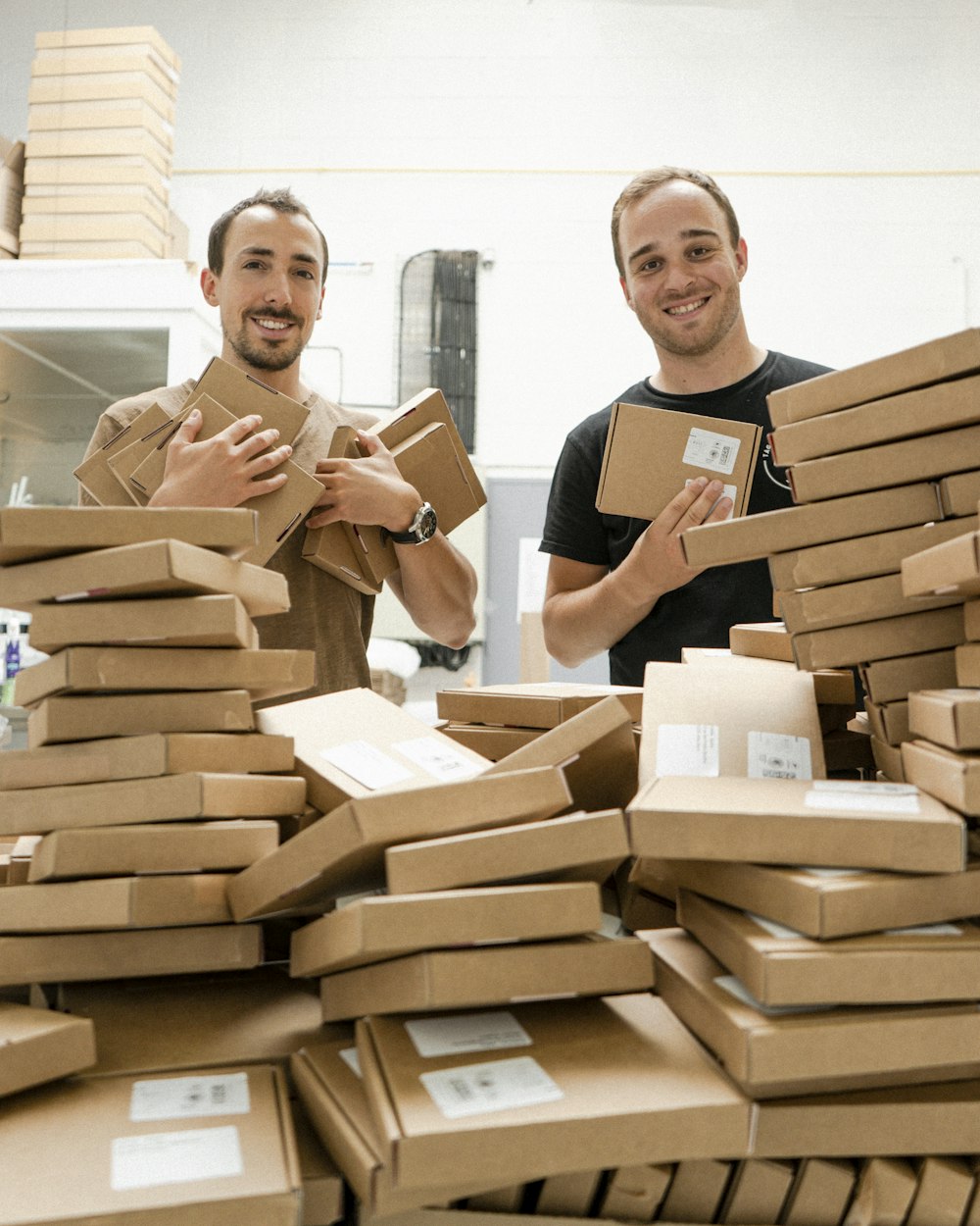 a couple of men standing next to a pile of boxes