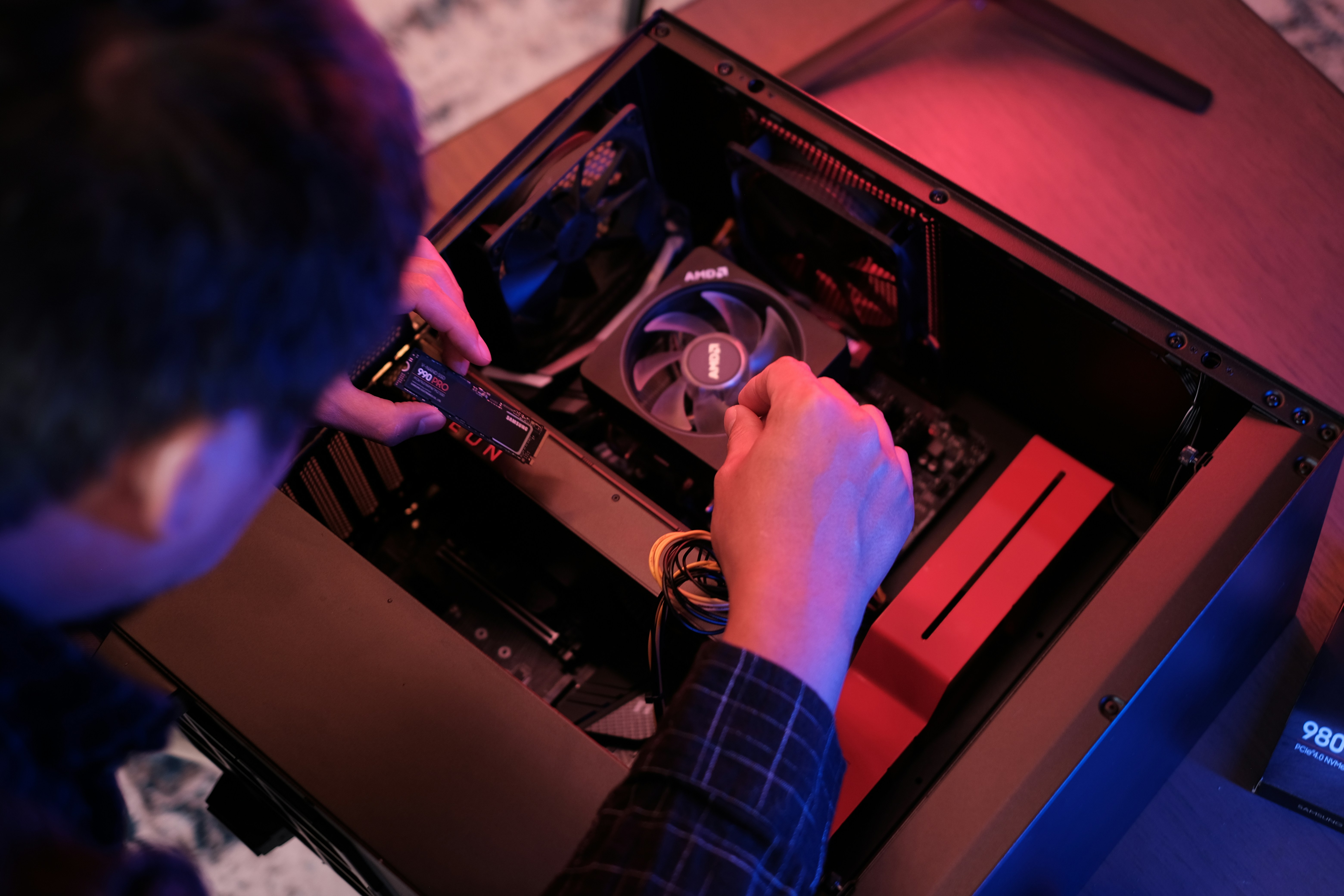 person soldering glowing computer graphics card workbench