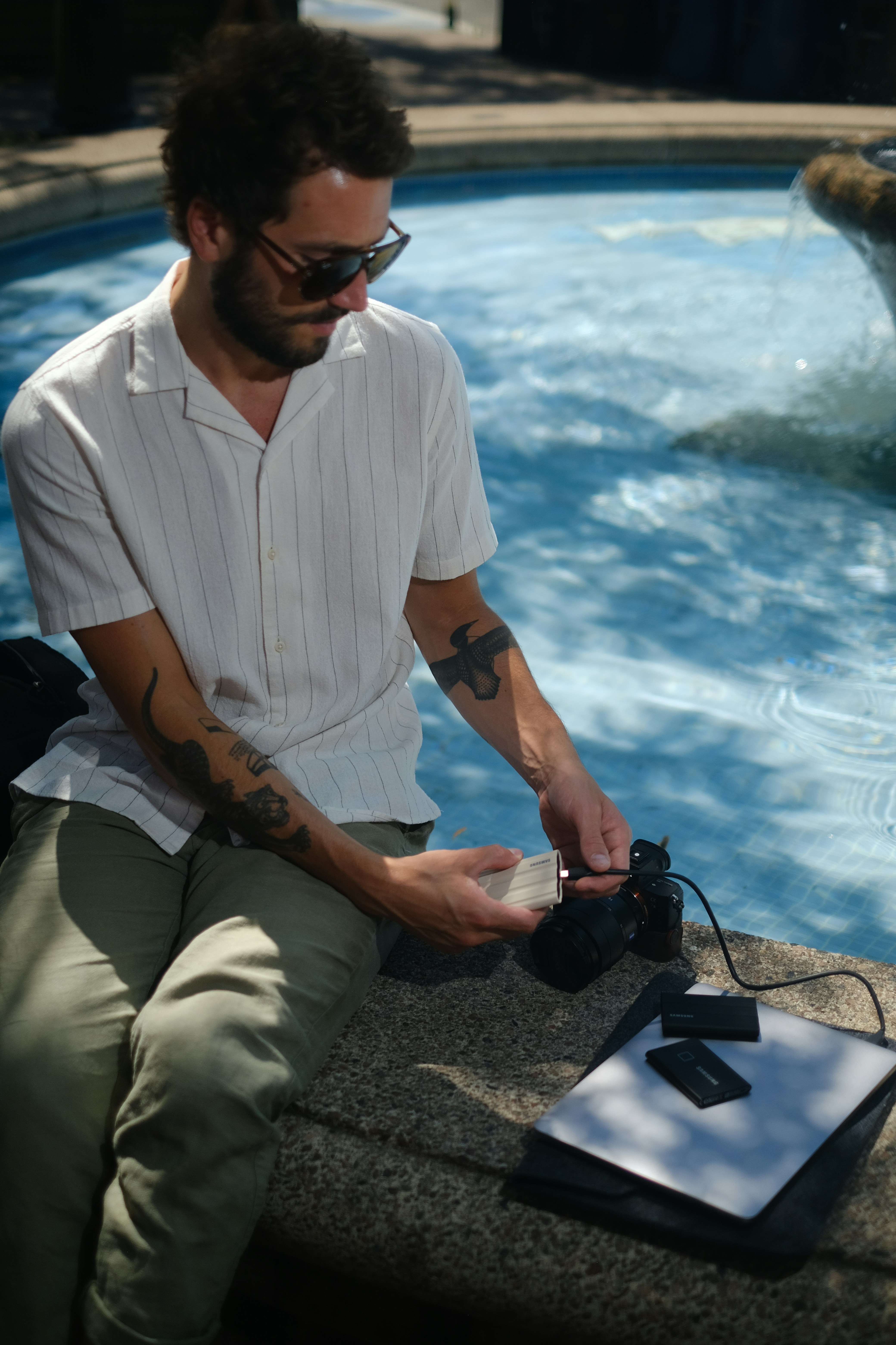 Un hombre sentado junto a una piscina