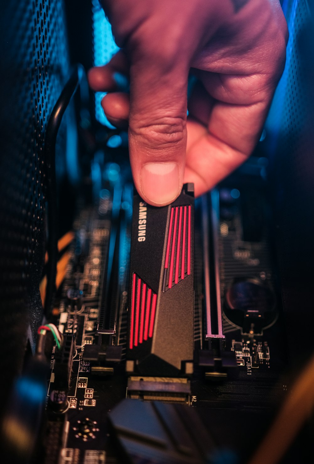 a hand holding a black and red electronic device