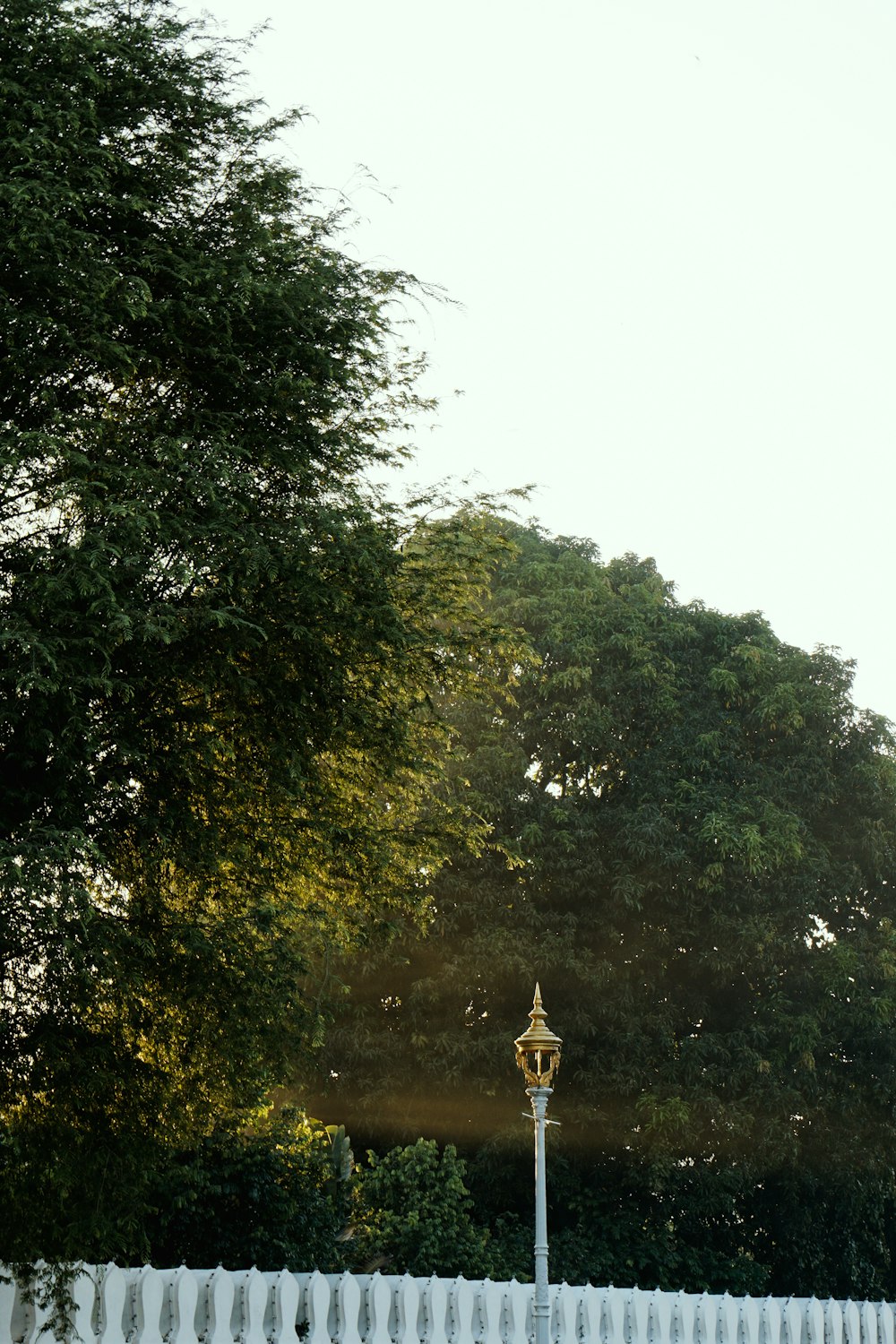 a white fence with a street light in front of it