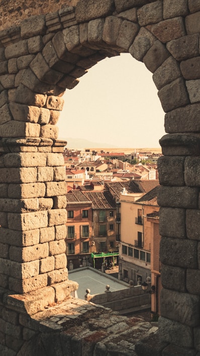 a view of a city from a stone archway