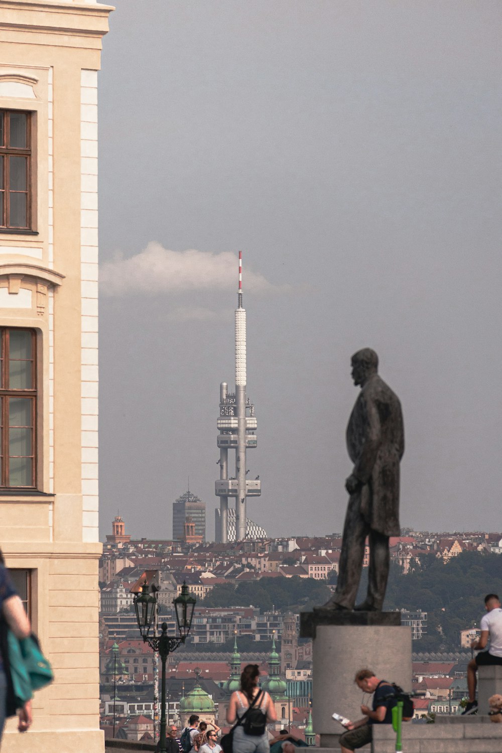 a statue of a person in front of a city