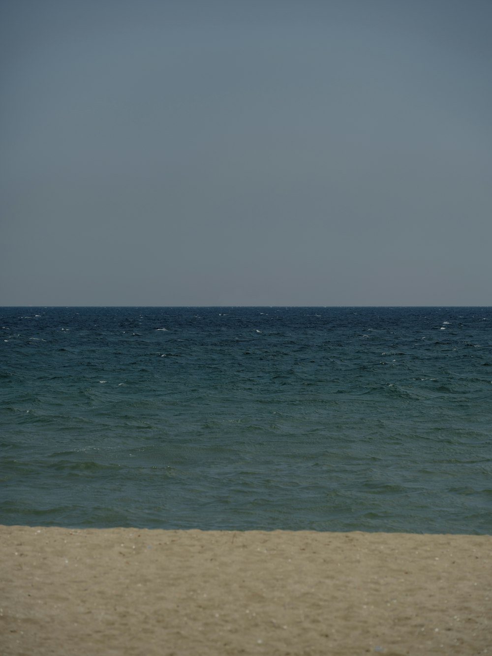 a sandy beach next to the ocean