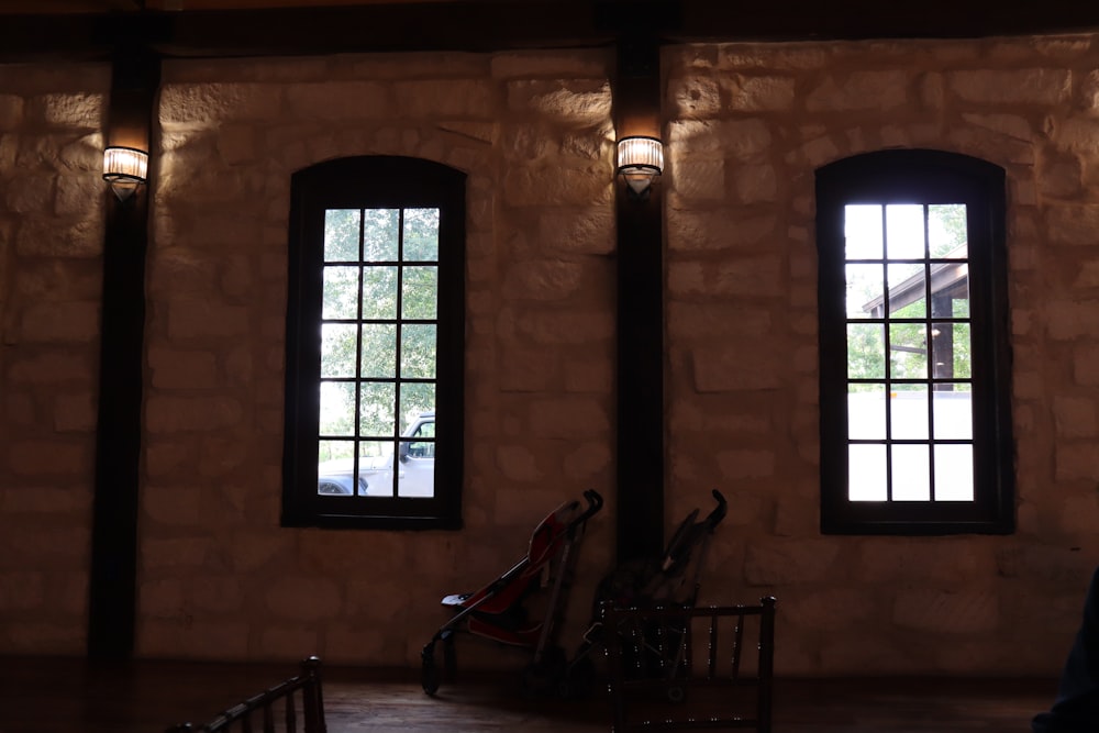 a brick building with windows and a chair in front of it