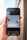 A smartphone held in a hand displays an image editing application featuring a design with two colorful hot air balloons and the phrase 'let's get creative' on a light blue background. The app interface shows various editing options at the bottom, such as styles, text, shapes, and more.