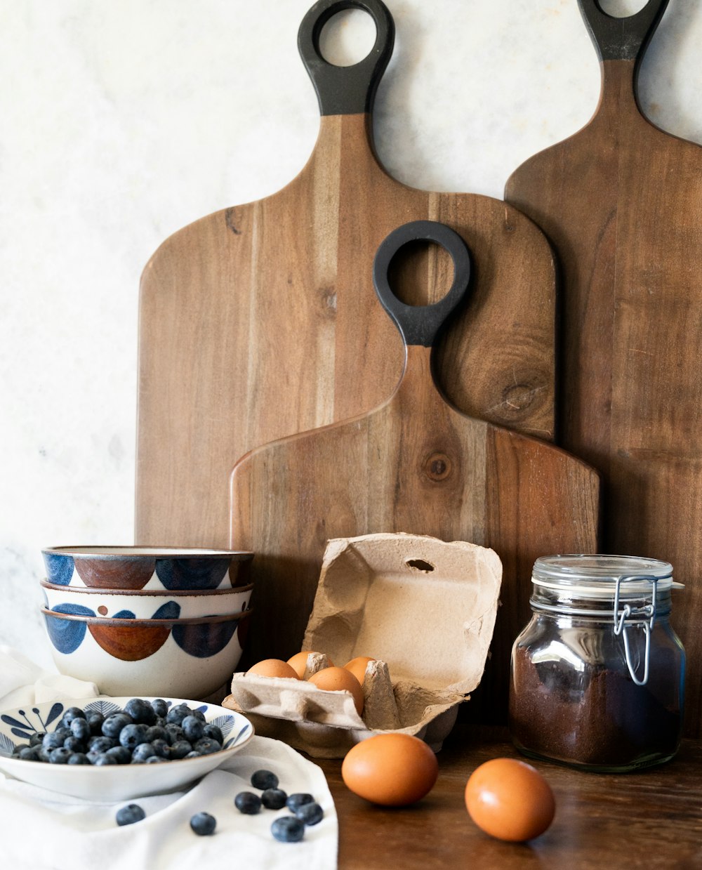 a wooden spoon and a bowl of fruit on a table