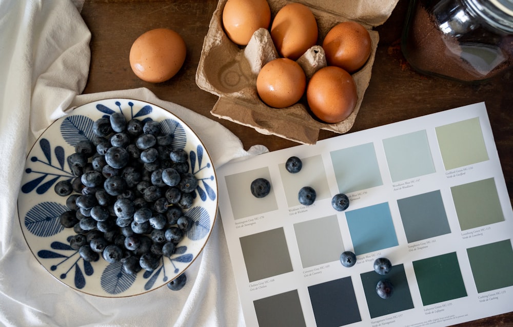 a plate of fruit and a bowl of berries on a table