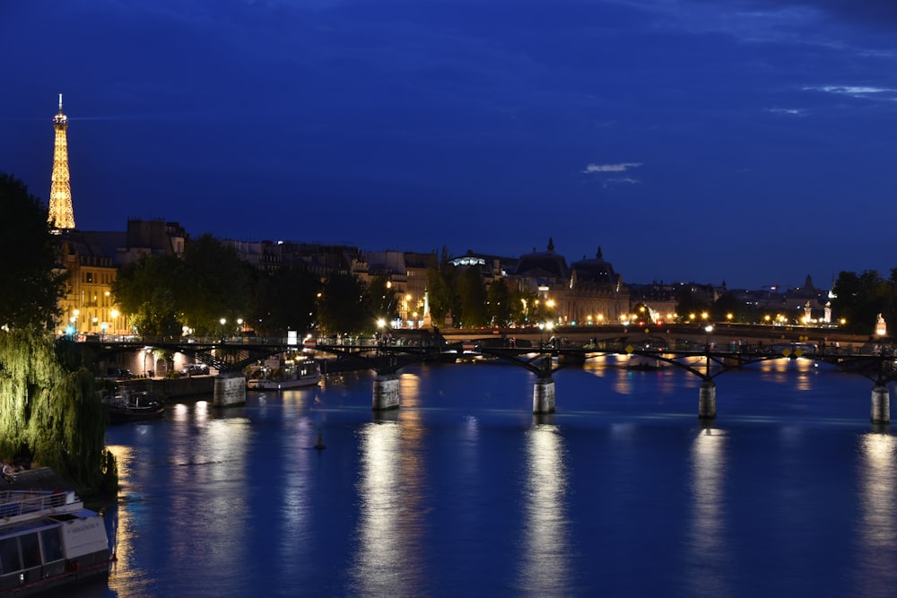 a bridge over a river with a city in the background